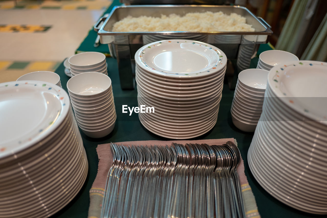 Close-up of stacked plates and cutlery on table