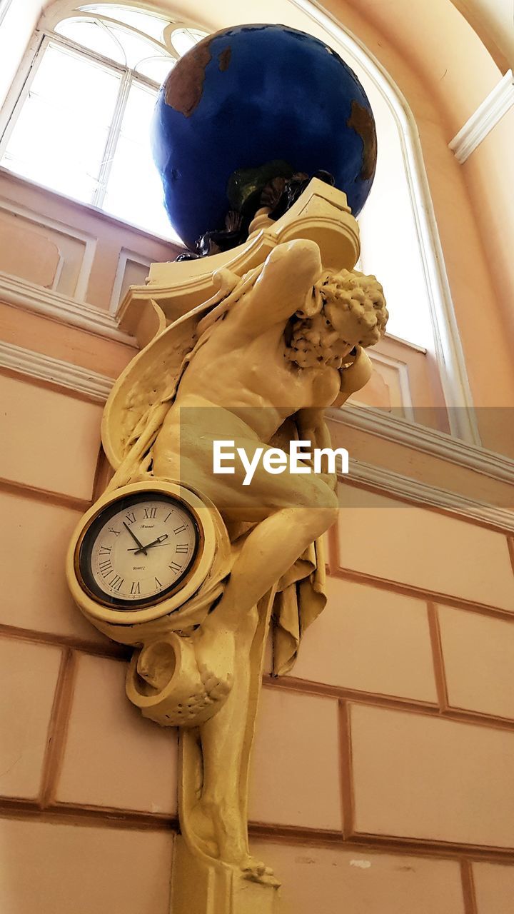 LOW ANGLE VIEW OF CLOCK ON CEILING
