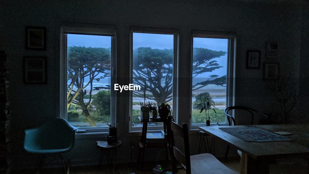 EMPTY CHAIRS AND TABLES IN WINDOW