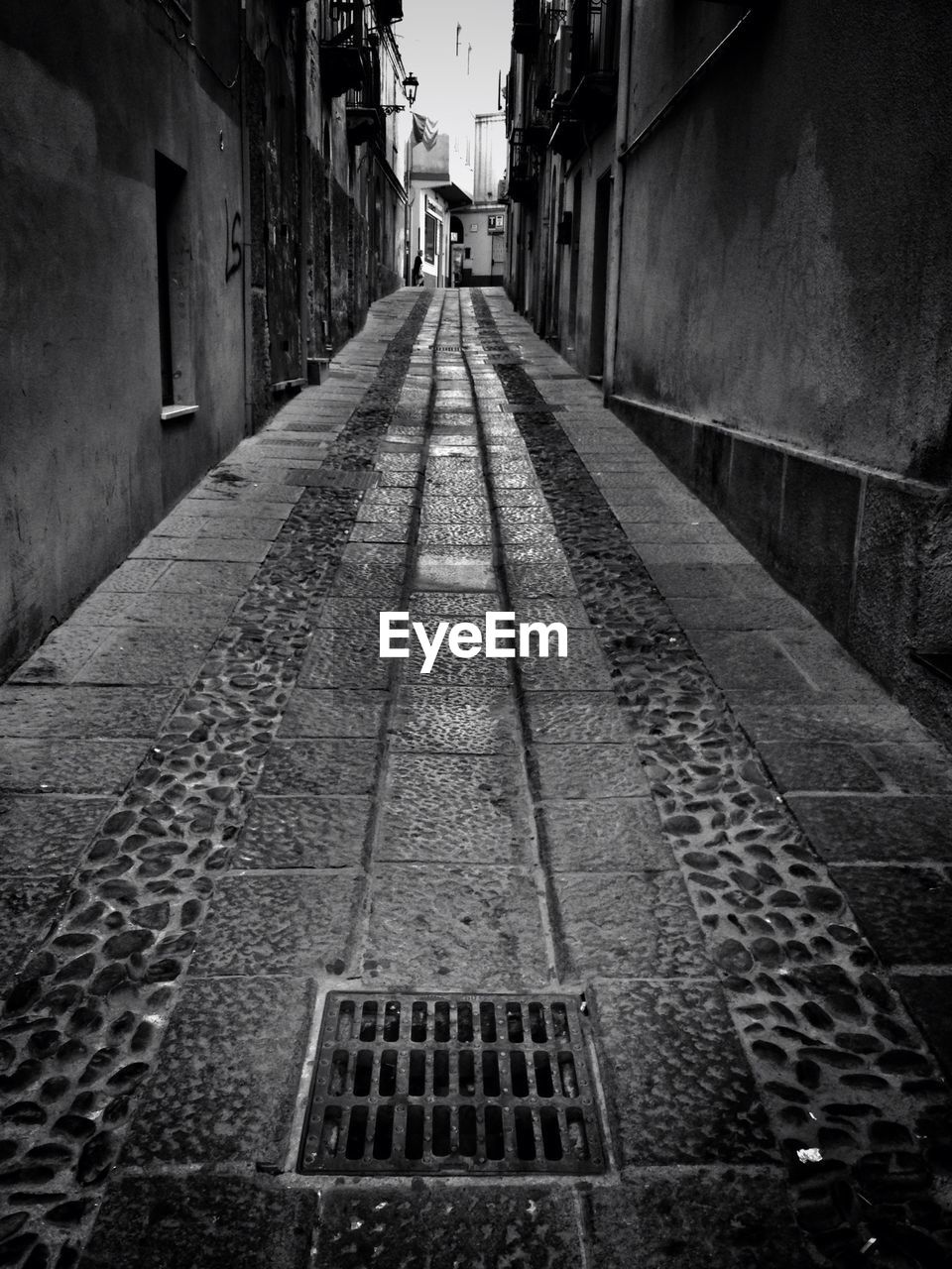 NARROW ALLEY WITH BUILDINGS IN BACKGROUND