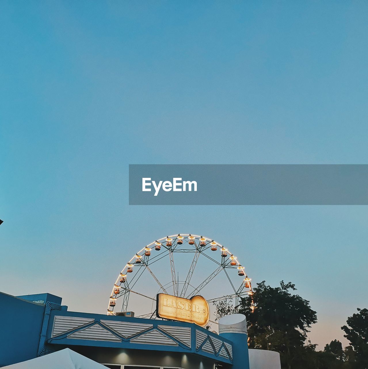 HIGH SECTION OF FERRIS WHEEL AGAINST CLEAR BLUE SKY