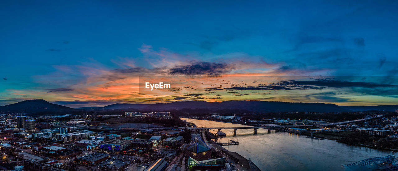 High angle view of buildings by sea against sky during sunset