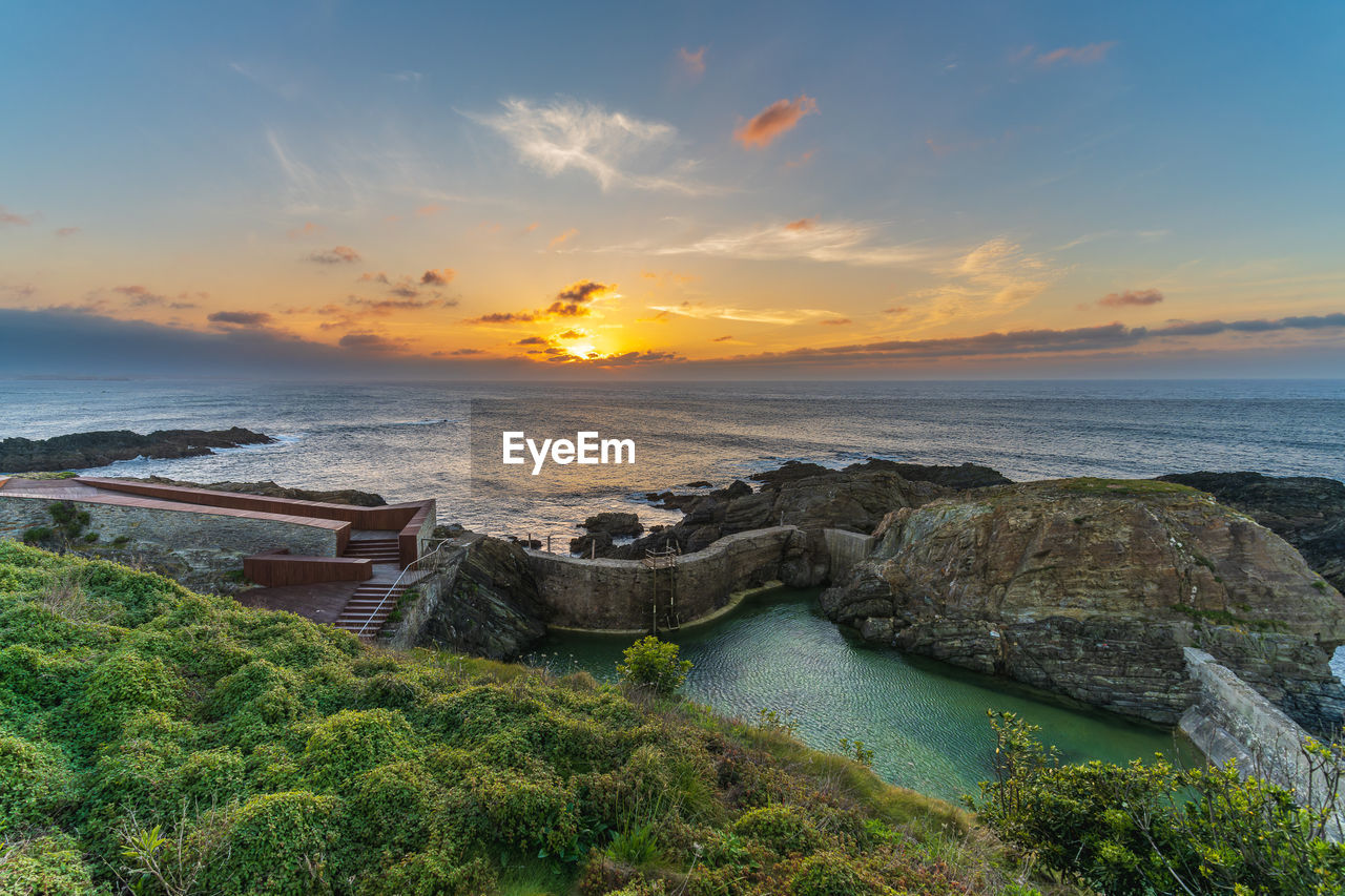 scenic view of beach against sky during sunset