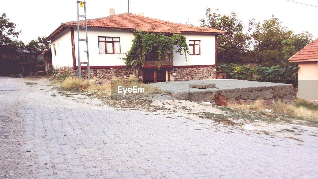 HOUSE BY ROAD AGAINST SKY