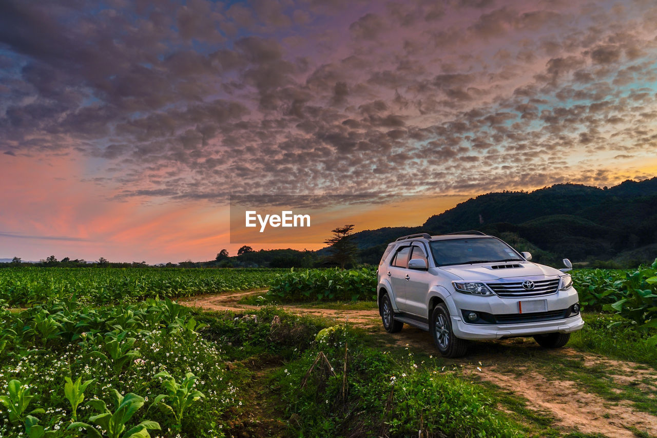 CAR PARKED ON LAND AGAINST SKY