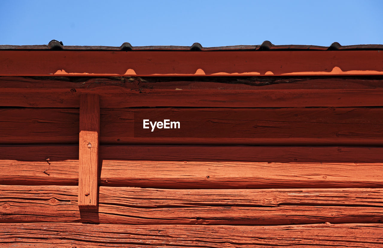 Detail of old beautiful red wooden house with blue sky