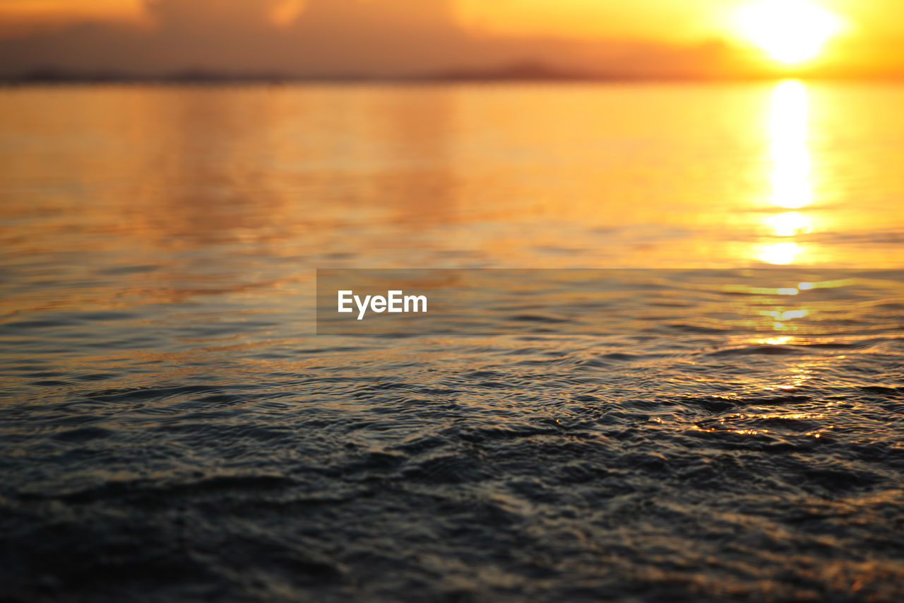 SURFACE LEVEL OF SEA AGAINST SUNSET SKY