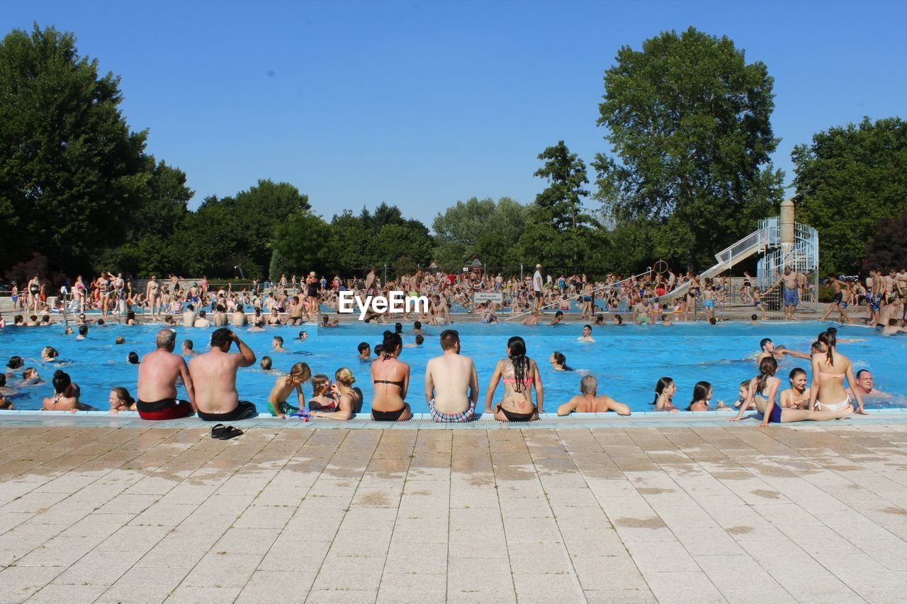 PEOPLE ON BEACH AGAINST CLEAR BLUE SKY