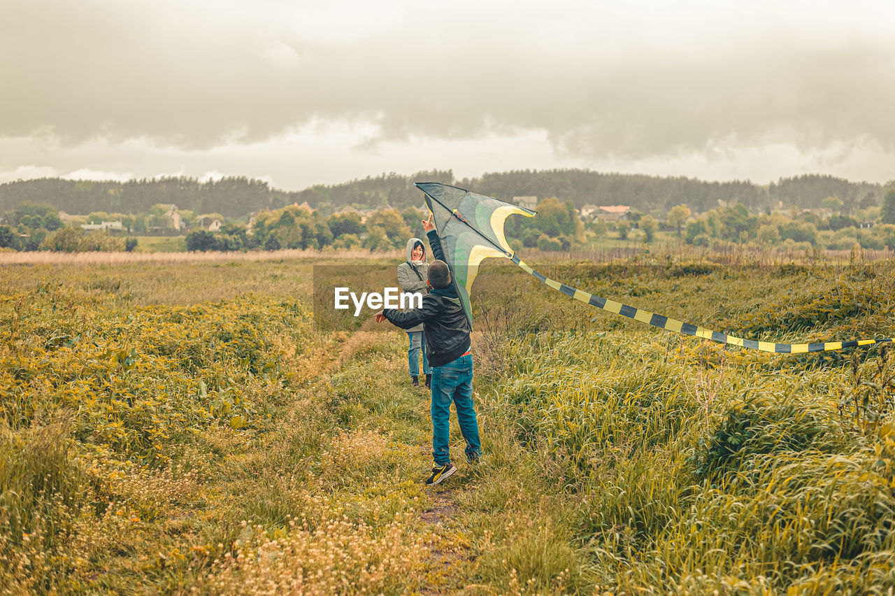 Rear view of man standing on land against sky