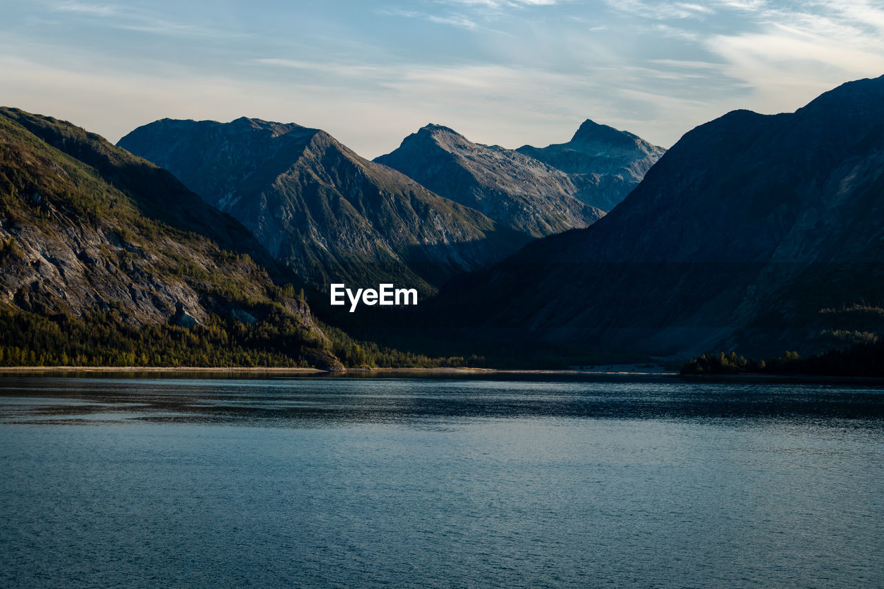 Scenic view of lake by mountains against sky