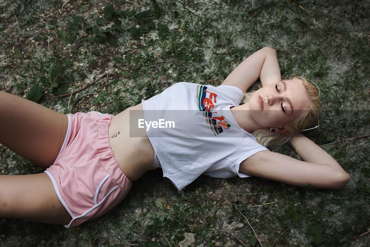 High angle view of woman lying down on footpath