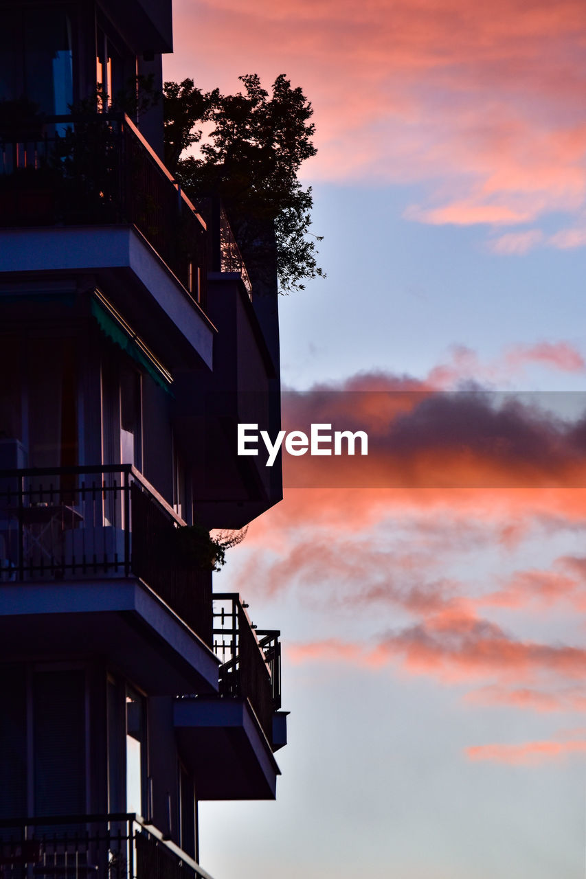 LOW ANGLE VIEW OF SILHOUETTE BUILDING AGAINST ORANGE SKY