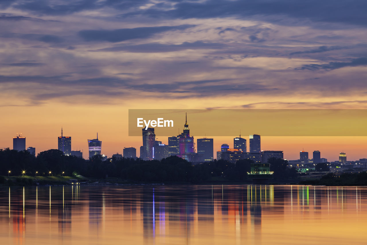 Modern buildings against sky during sunset