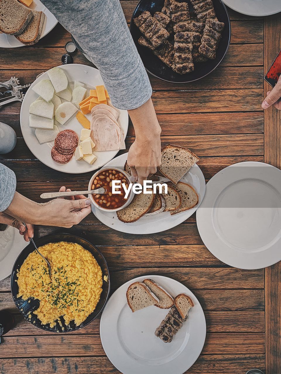 Breakfast setting, hand reaching for bread.