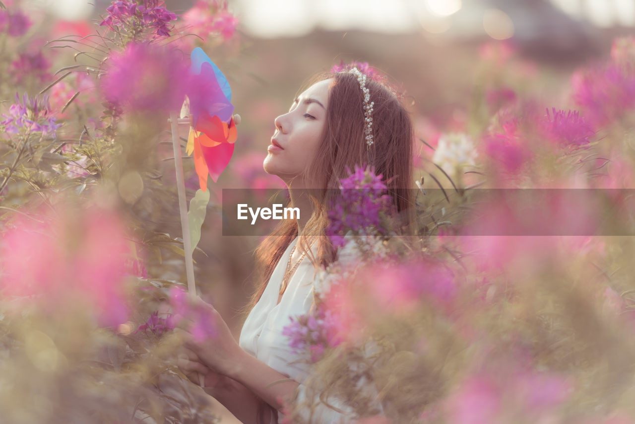 Woman standing on pink flowering plants