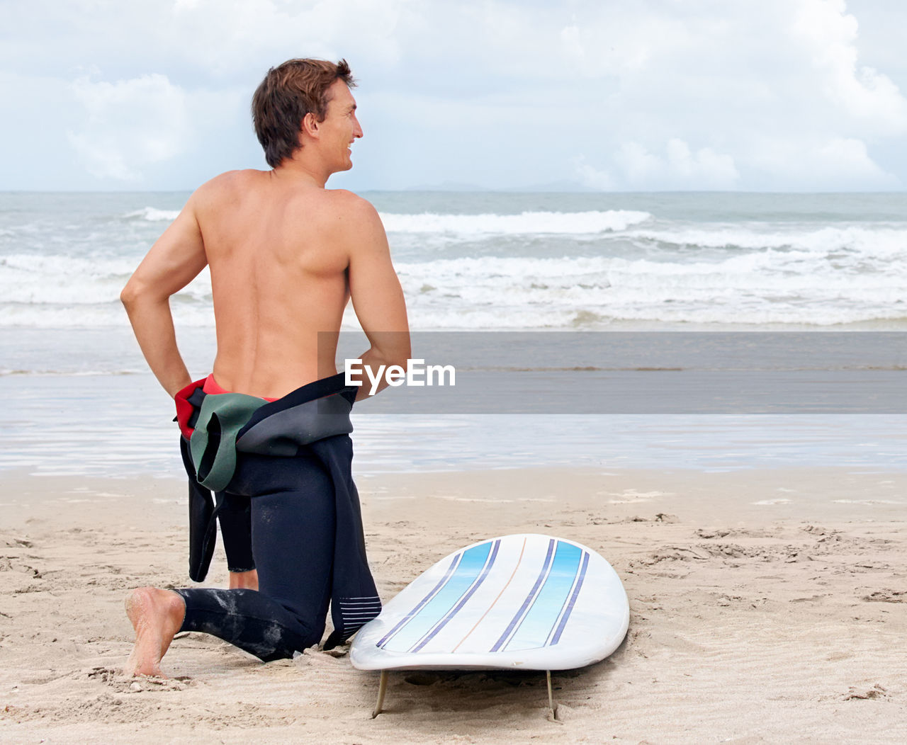 beach, land, sea, water, surfing, surfing equipment, surfboard, one person, men, adult, nature, sports, vacation, holiday, sand, trip, sky, leisure activity, water sports, lifestyles, motion, day, summer, full length, sports equipment, relaxation, standing, cloud, clothing, young adult, travel, person, outdoors, horizon over water, looking, swimwear, exercising, horizon, wetsuit, rear view, wave, beauty in nature, body of water, travel destinations, swimming trunks