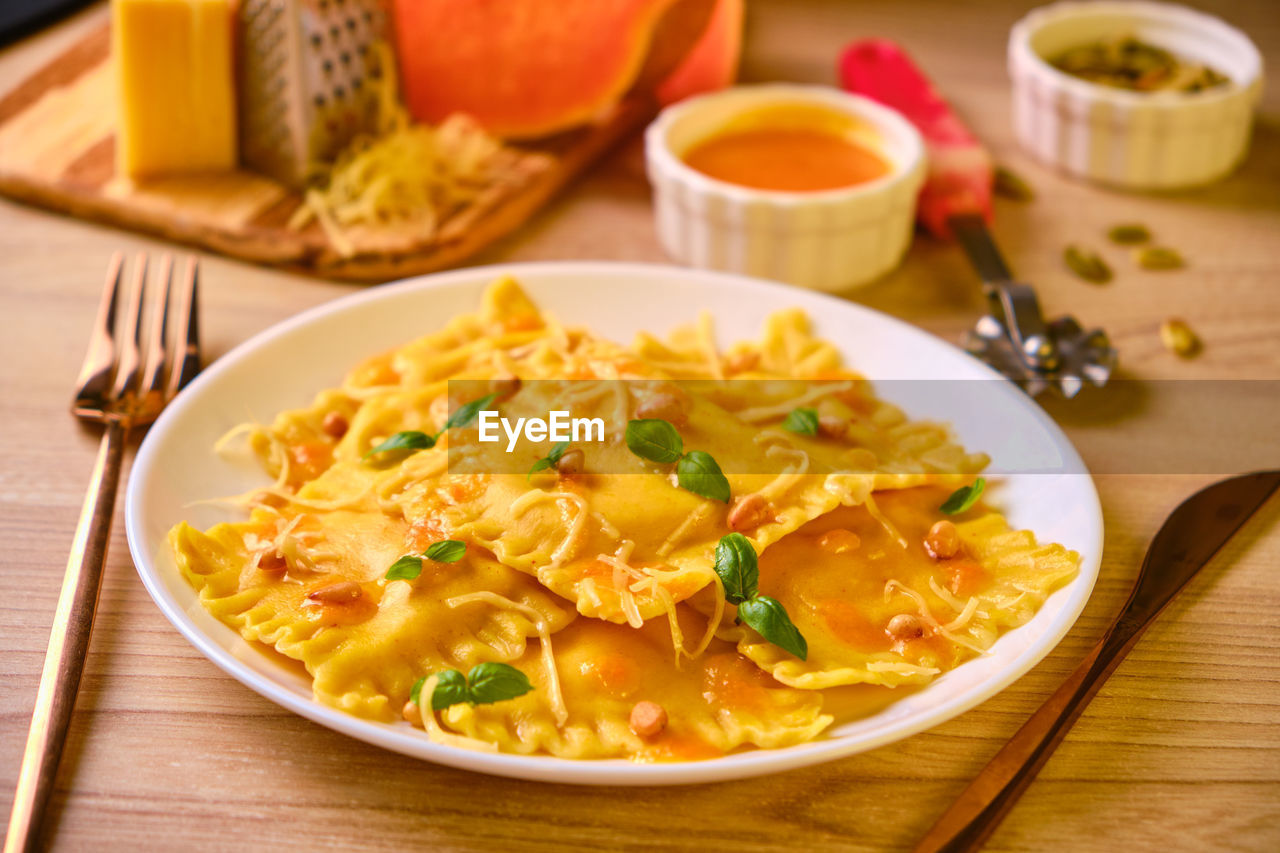 Homemade pumpkin ravioli with ricotta cheese served basil