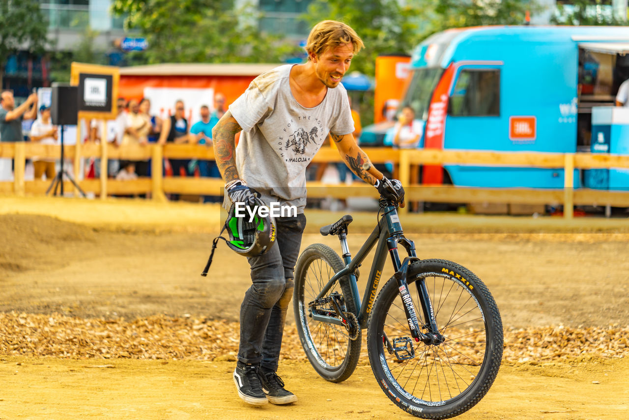 FULL LENGTH OF MAN RIDING BICYCLE ON SWING