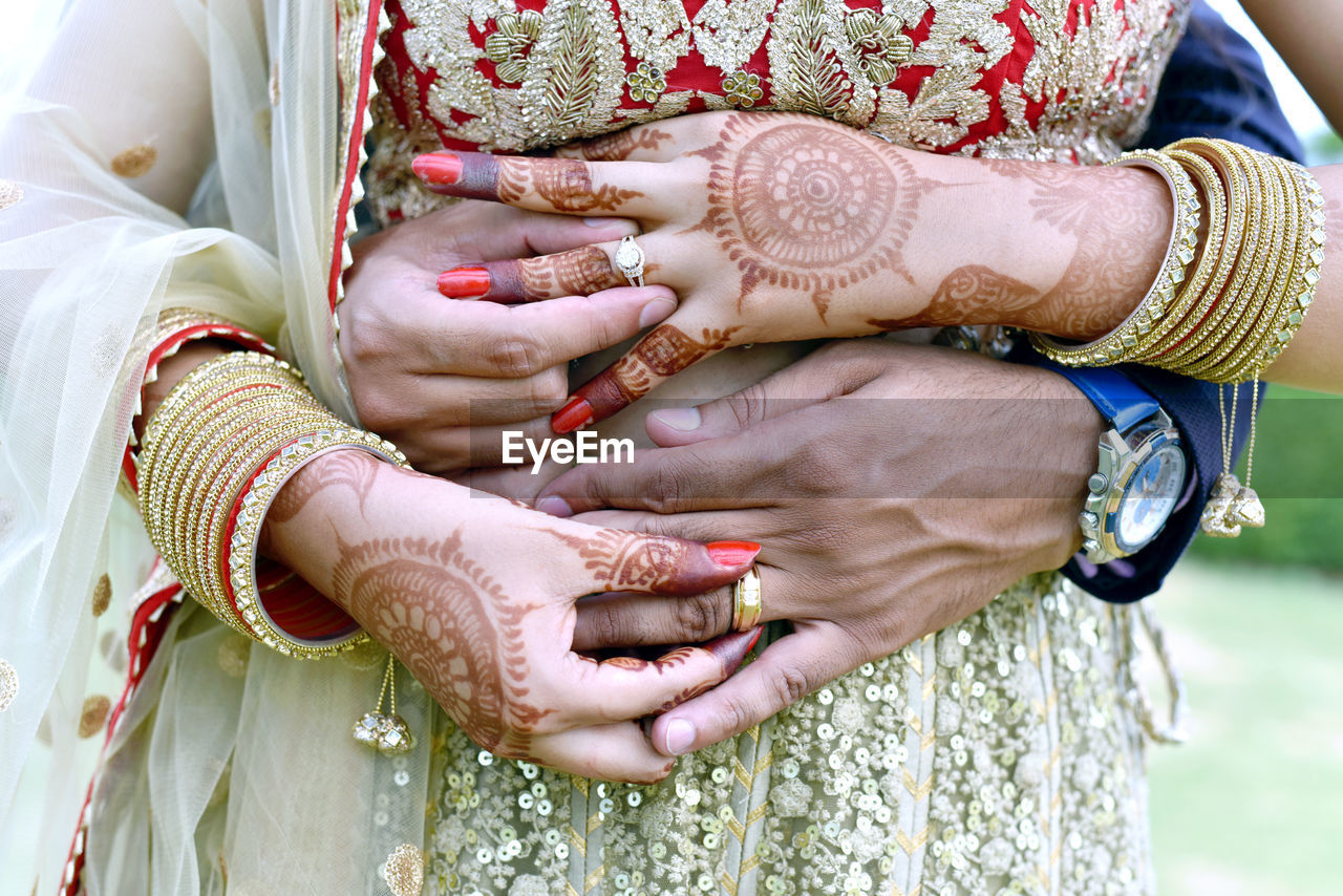 MIDSECTION OF WOMAN WITH HANDS ON TABLE