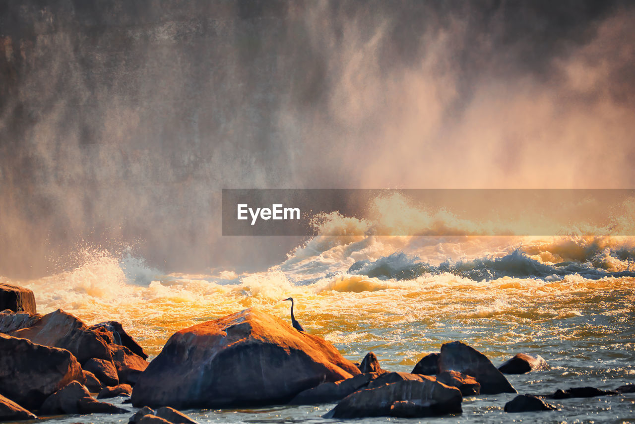 PANORAMIC SHOT OF ROCKS AGAINST BRIGHT SUN