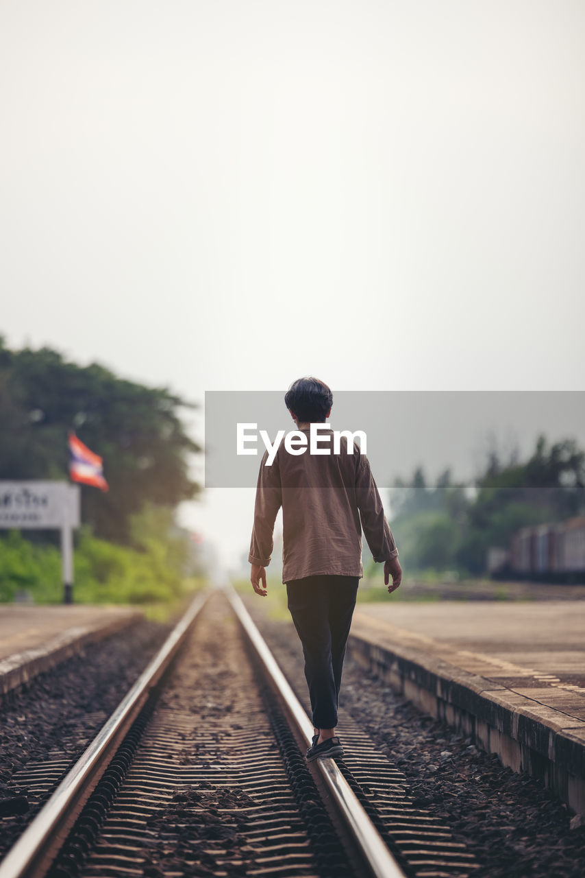 Man walk away on railroad with warm light. selective focus. traveler man on railroad. person
