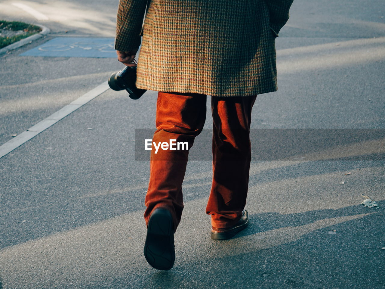 Low section of man walking on road