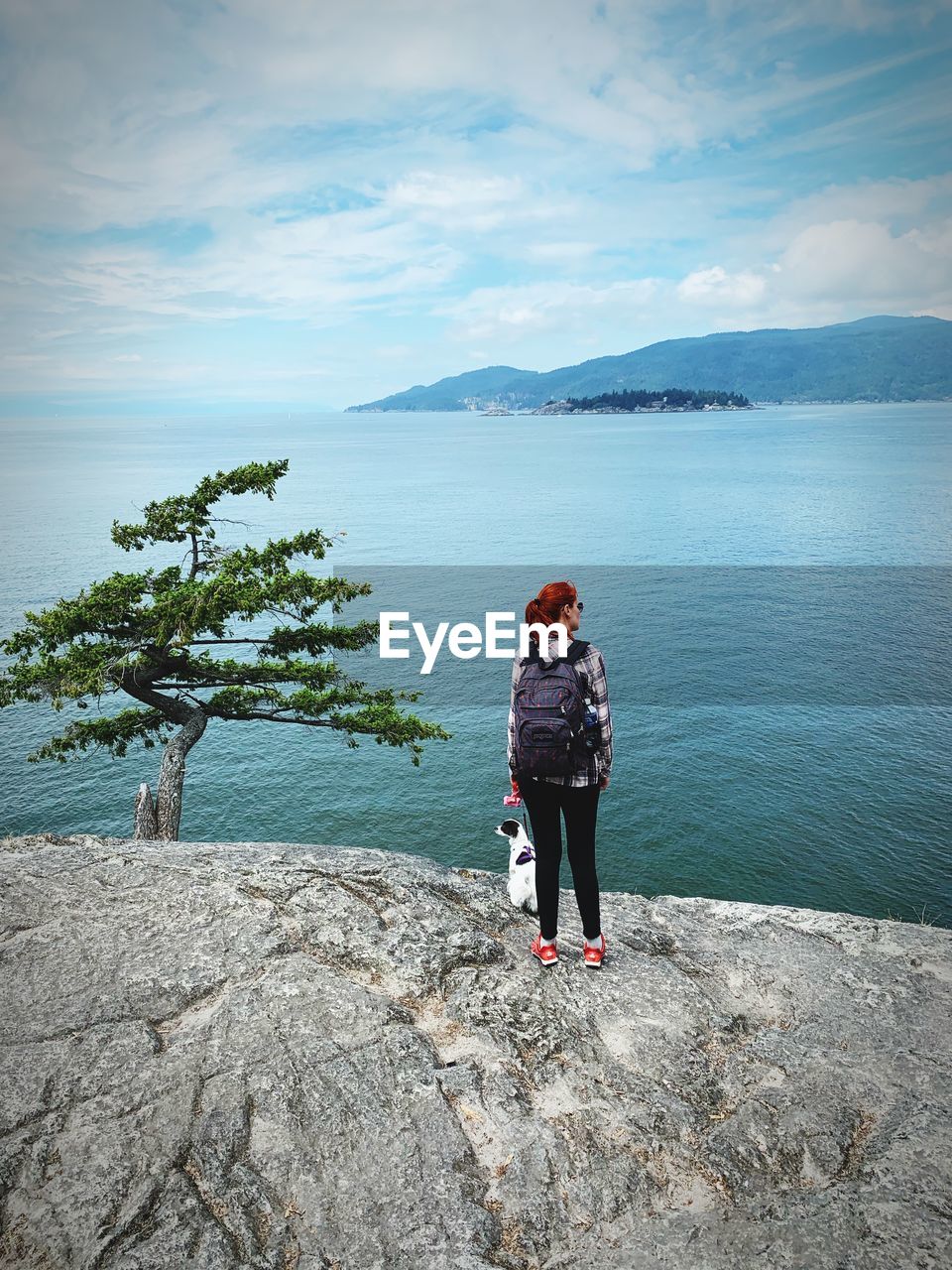 MAN STANDING ON SHORE AGAINST SKY