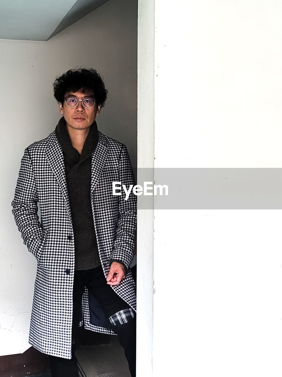 one person, adult, glasses, portrait, clothing, men, front view, standing, copy space, eyeglasses, indoors, looking at camera, photo shoot, fashion, black, casual clothing, business, pattern, leaning, young adult, architecture, mature adult, full length, lifestyles, business finance and industry, person, sunglasses, wall - building feature, spring, three quarter length, looking, businessman