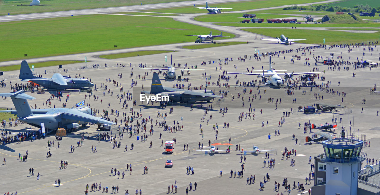 HIGH ANGLE VIEW OF AIRPLANE FLYING OVER PEOPLE