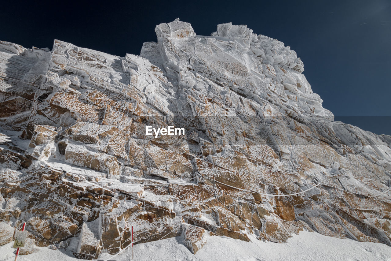 Low angle view of snowcapped mountain against sky