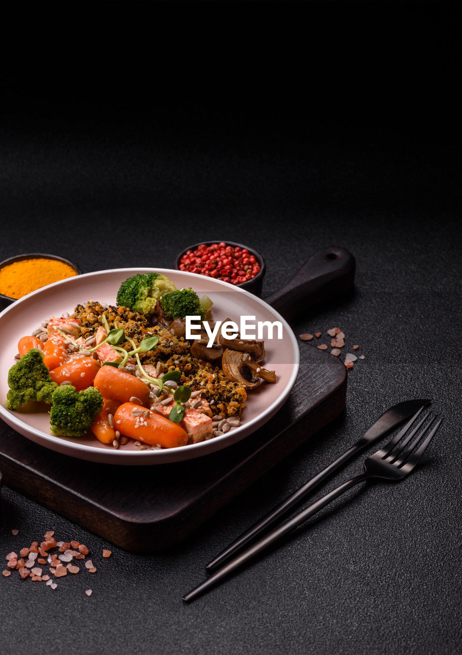 food and drink, food, healthy eating, studio shot, vegetable, wellbeing, black background, kitchen utensil, eating utensil, dish, freshness, meal, no people, plate, herb, indoors, fork, meat, produce, bowl, crockery, cuisine, spice, green, vegetarian food, dinner, fruit, garnish, dark, copy space, savory food, carrot, root vegetable, still life, household equipment, pasta