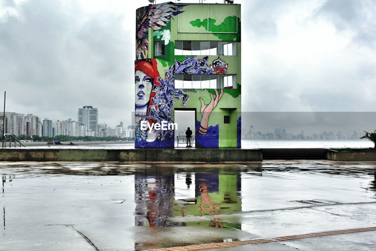 VIEW OF BUILDINGS AGAINST CLOUDY SKY