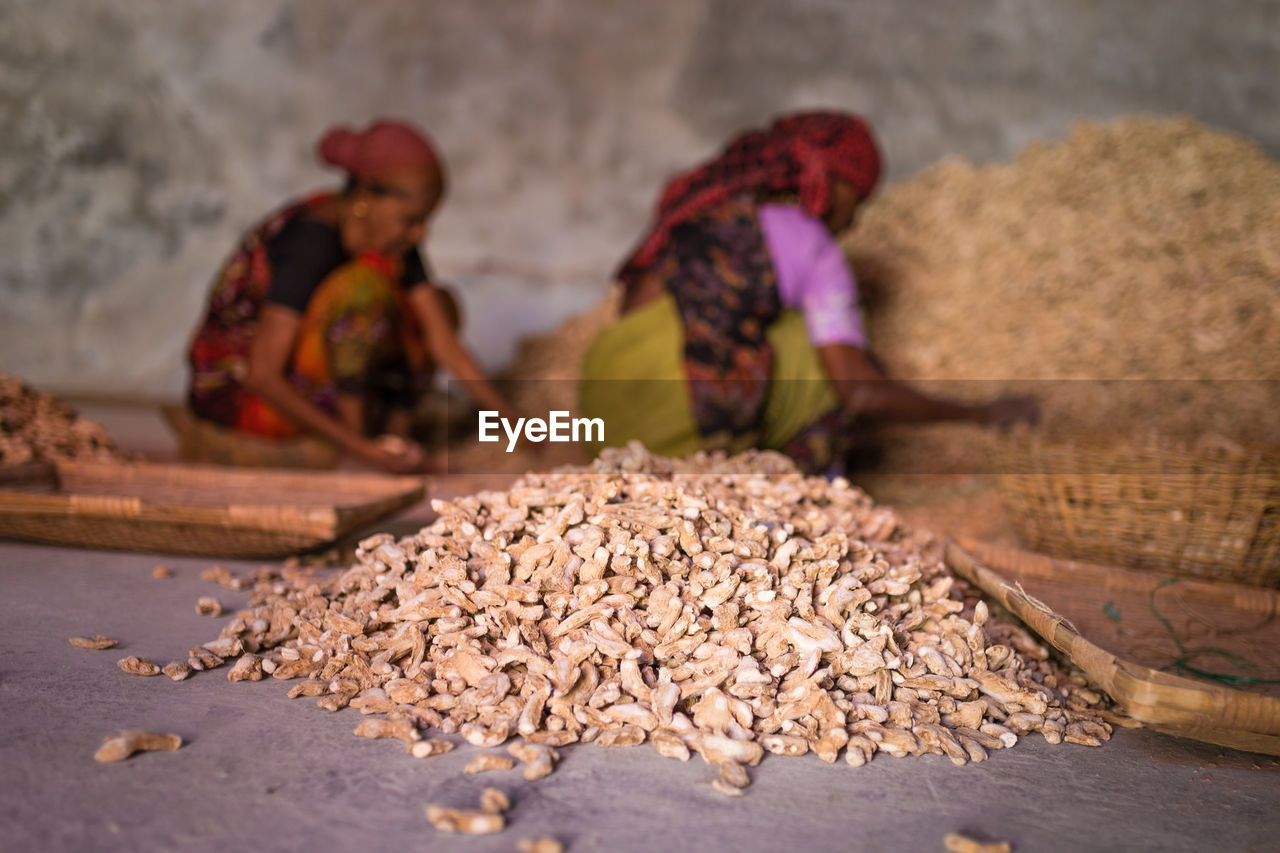 Close-up of ginger with women working in background