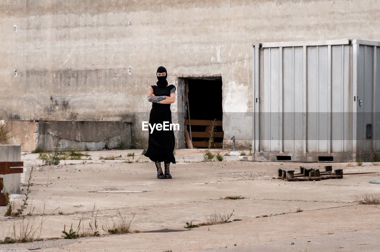 Portrait of woman in costume standing against old factory