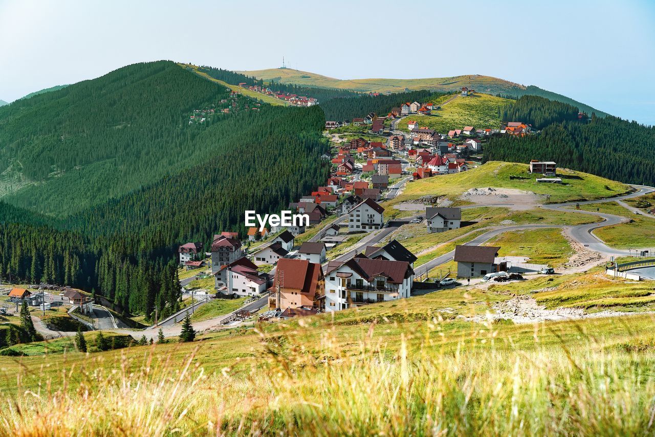 Houses on field by mountain against sky. mountain resort in summer