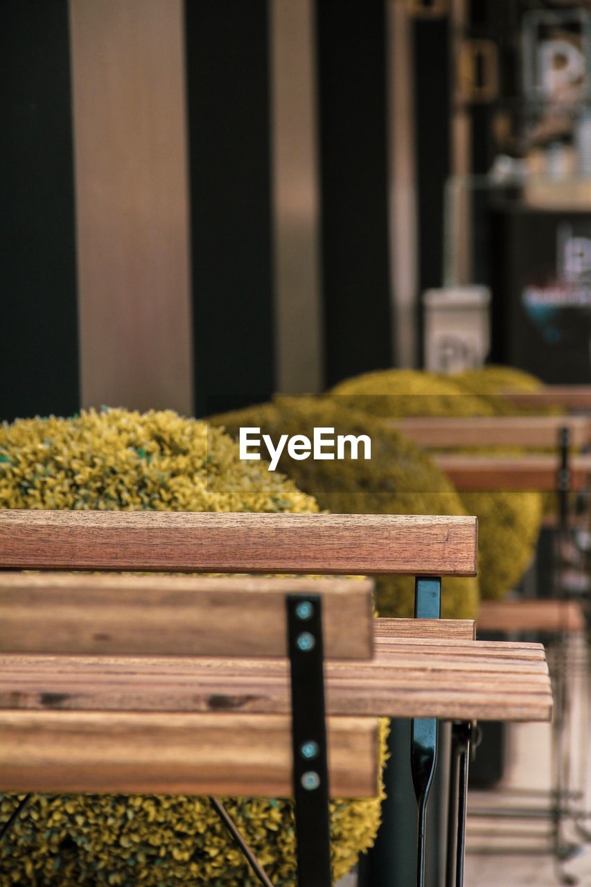 CLOSE-UP OF EMPTY CHAIRS AND TABLE AGAINST RAILING