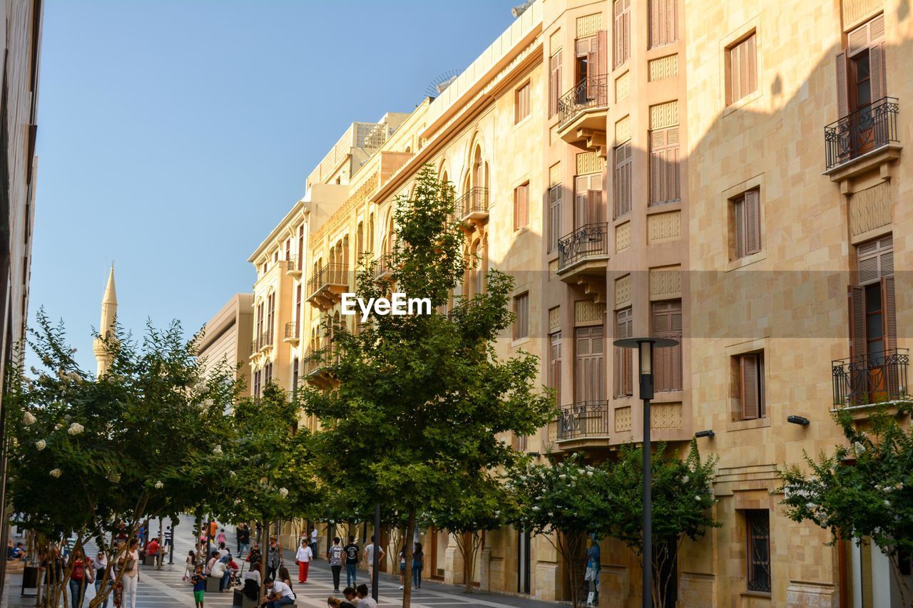 People on street amidst buildings in city