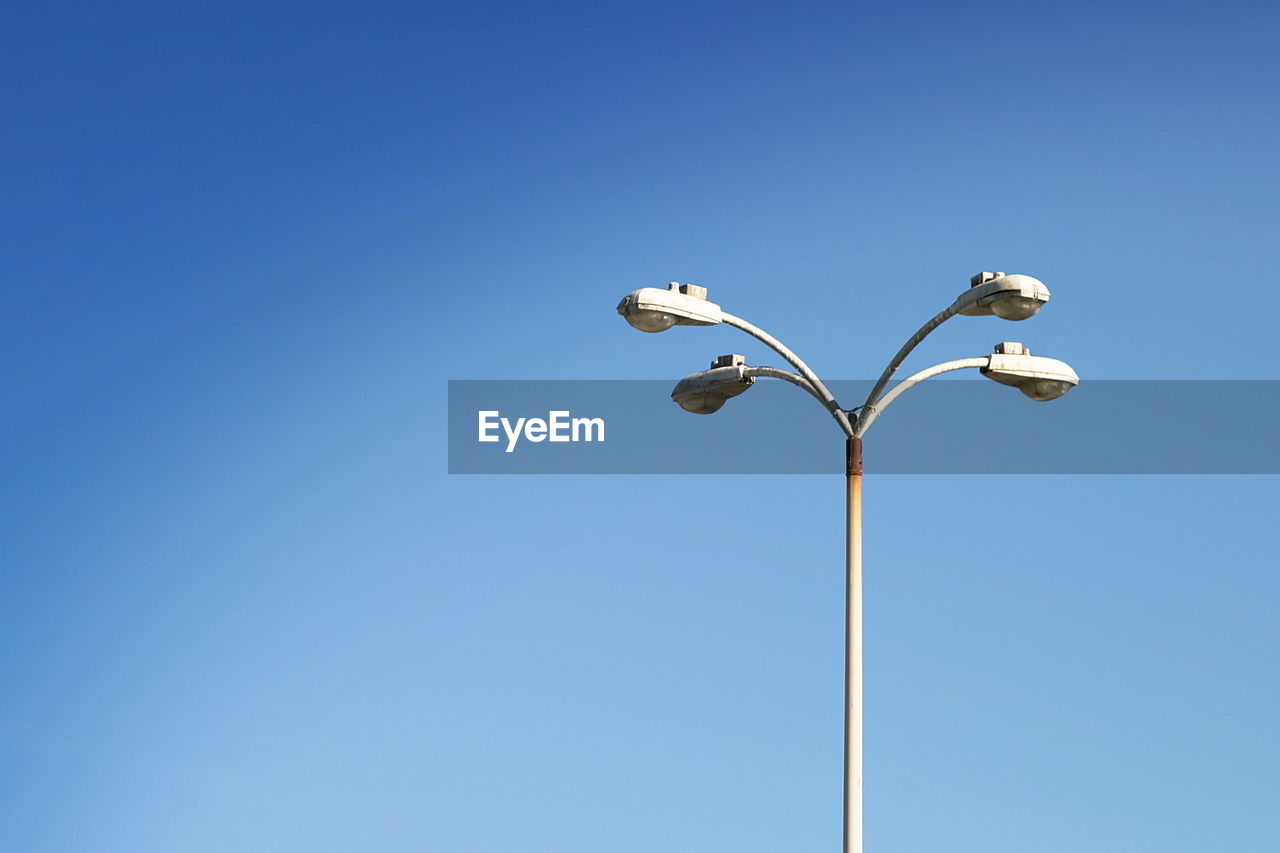 Low angle view of street light against clear blue sky