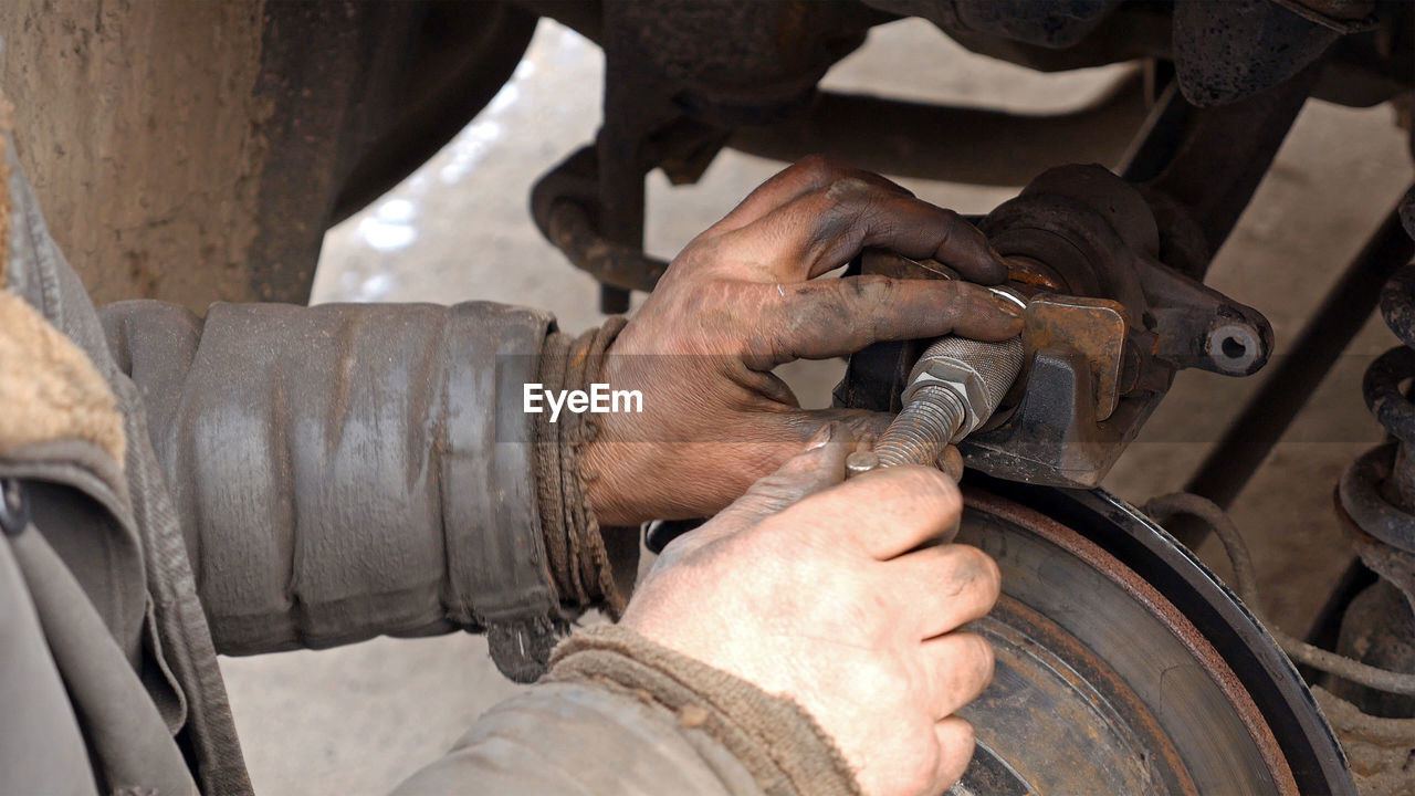 Cropped image of male mechanic repairing car