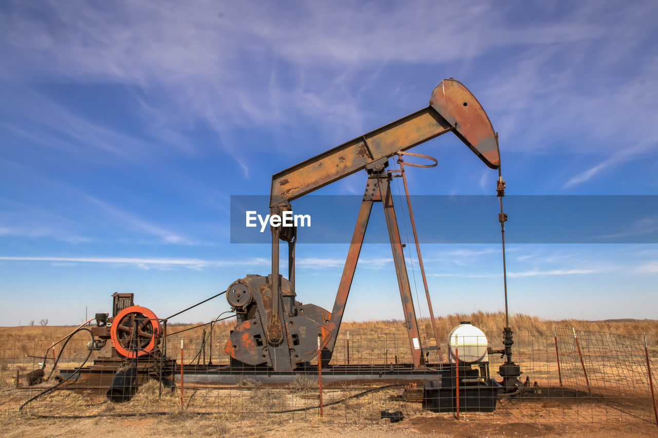 Oil well against sky