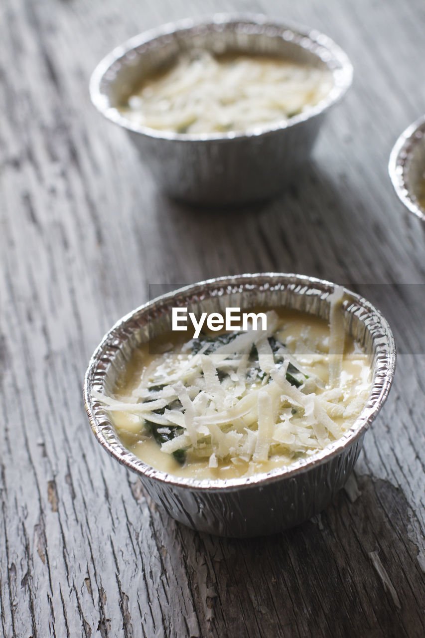 High angle view of casseroles with eggs and parmesan cheese