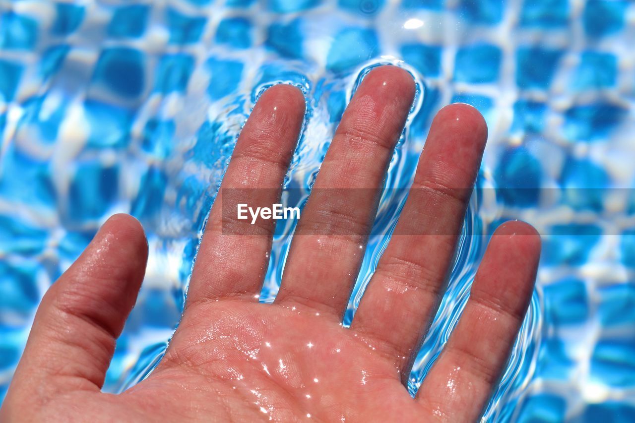 Cropped hand on swimming pool