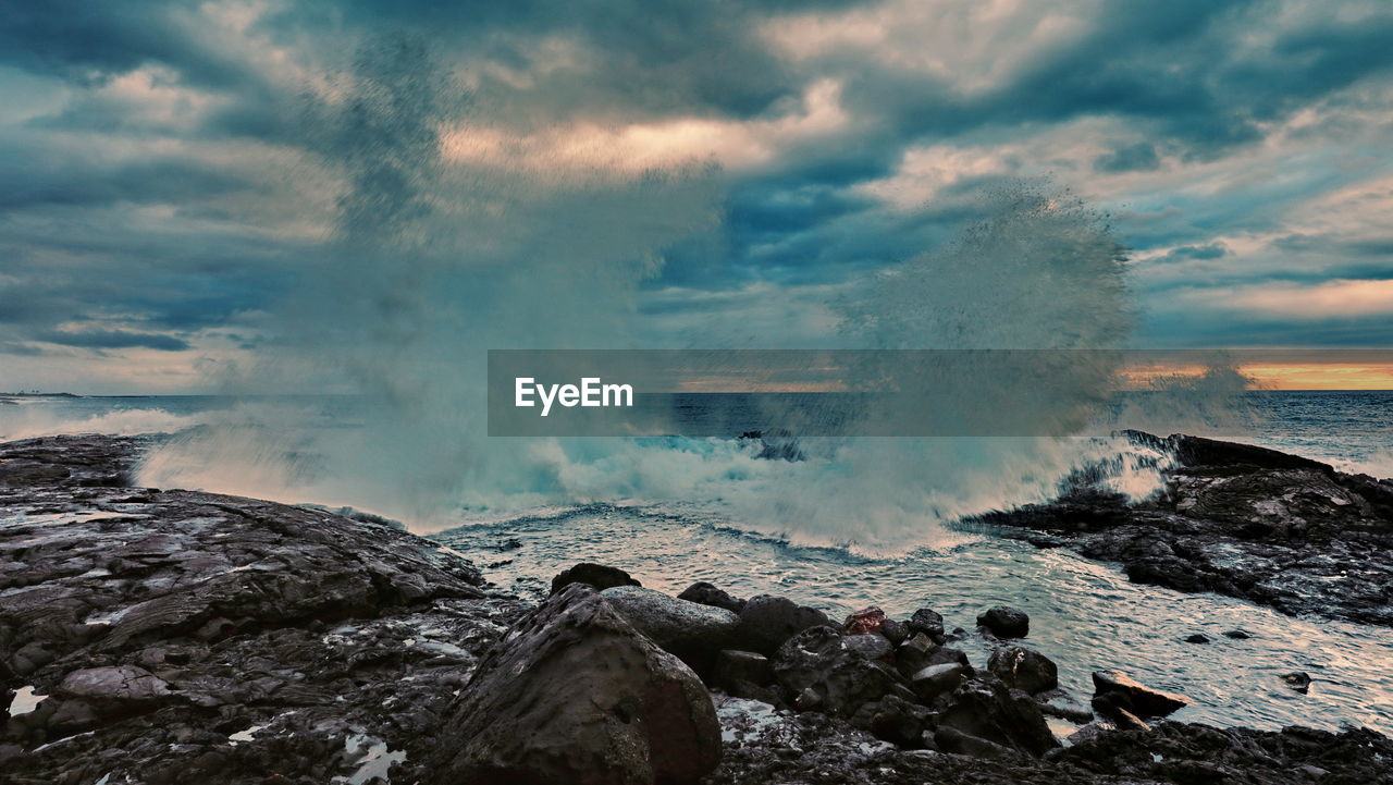 Panoramic shot of rocks by sea against sky