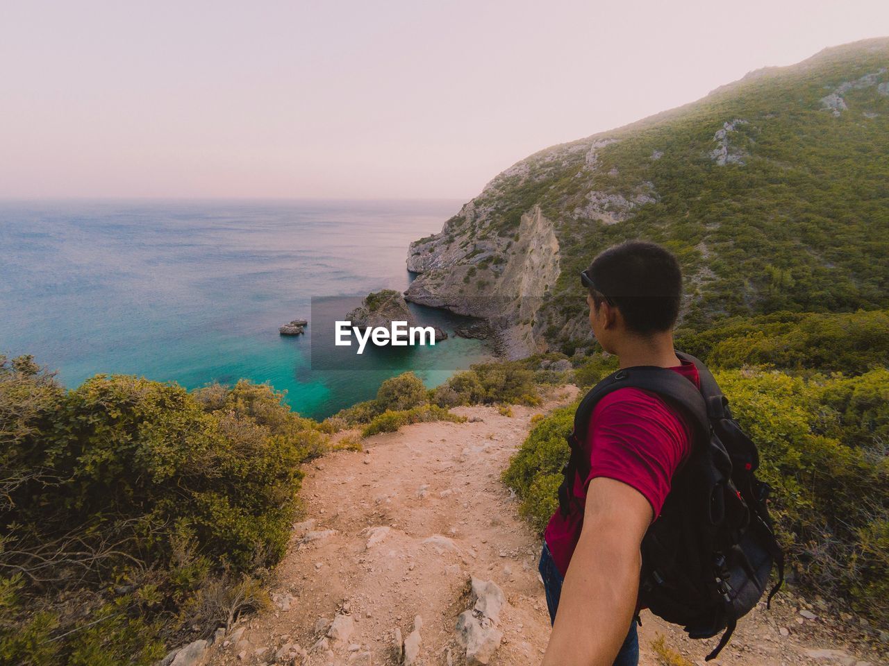 Rear view of man looking at sea against sky