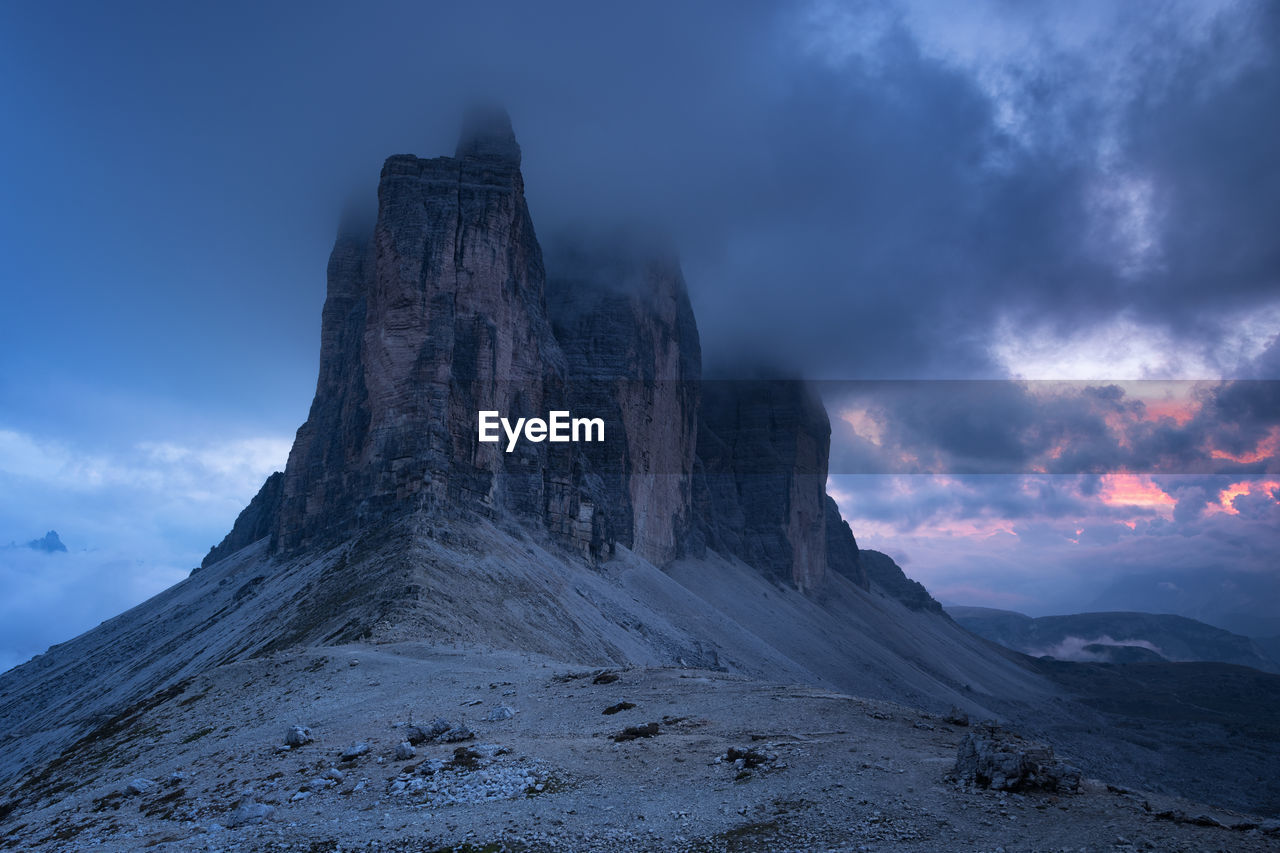 Rock formations against cloudy sky