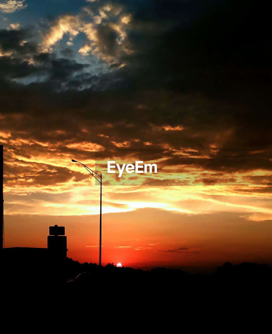 Silhouette electricity pylon against sky during sunset