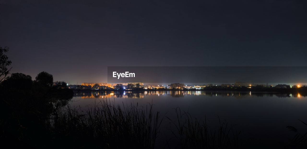 SCENIC VIEW OF LAKE AGAINST ILLUMINATED SKY AT NIGHT