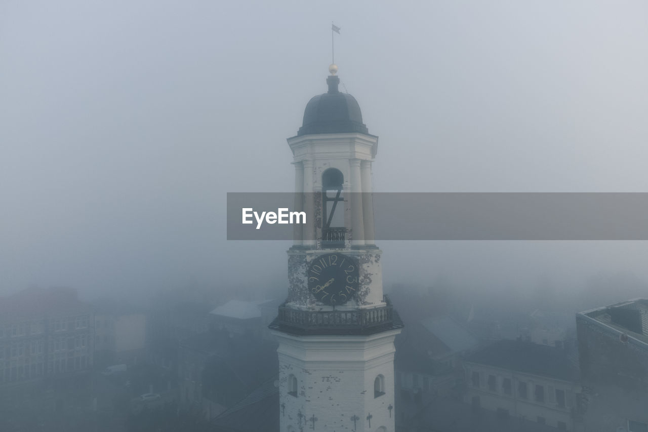 Ancient clock tower in the historical center of vyborg. foggy morning. object of cultural heritage