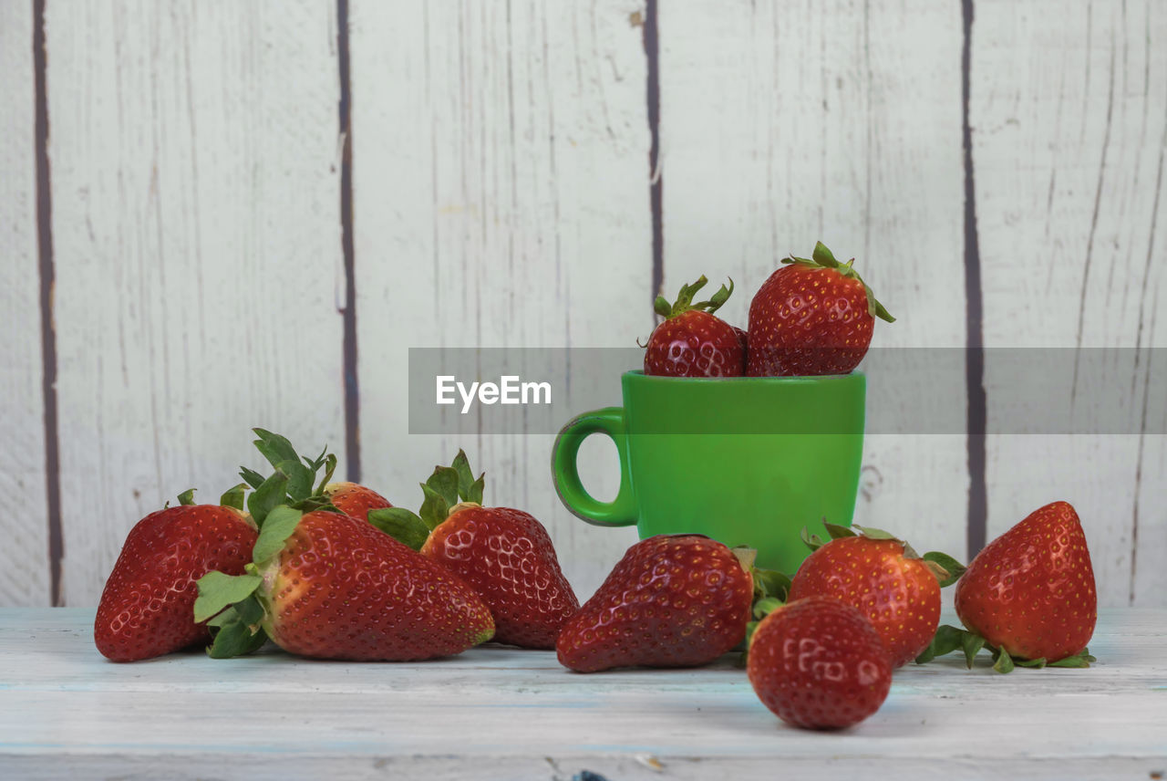 CLOSE-UP OF STRAWBERRIES IN PLATE ON TABLE