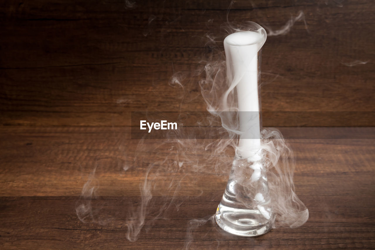 Close-up of smoke coming out from dry ice against table